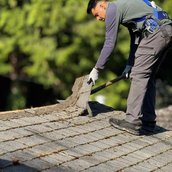 Invictus Roofing technician performing roof shingle repair on damaged asphalt roof in Cherokee County, GA.